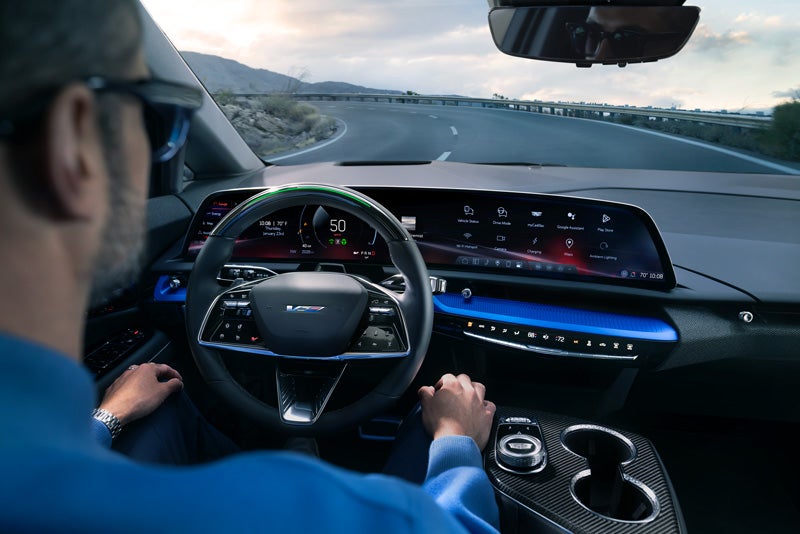 Front View of the 2026 OPTIQ-V Driving Through the Dusk Utilizing its Headlights | Flow Cadillac in Winston Salem NC