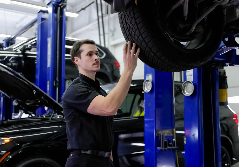 Service tech examining the tire of a car